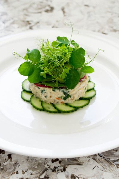 a white plate topped with cucumbers and greens