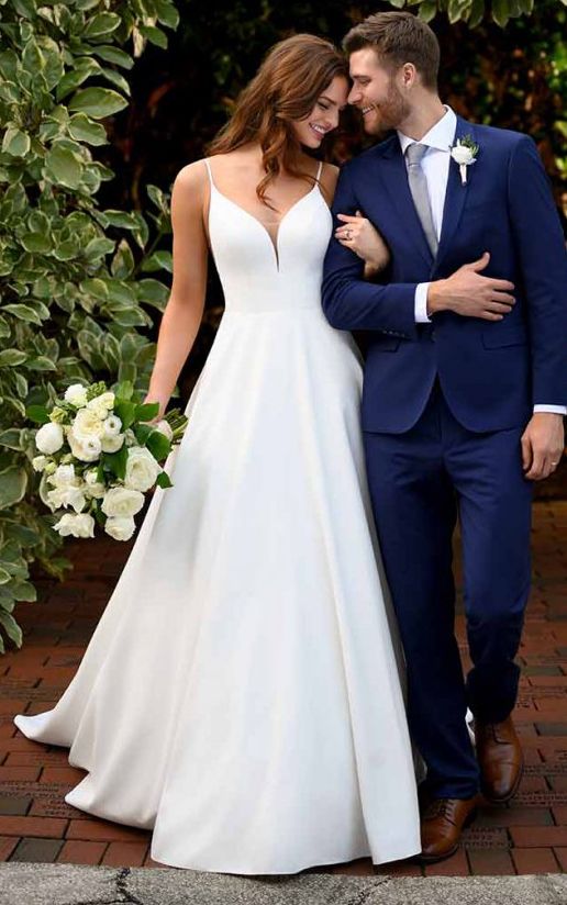 a bride and groom are standing in front of some greenery at their wedding day