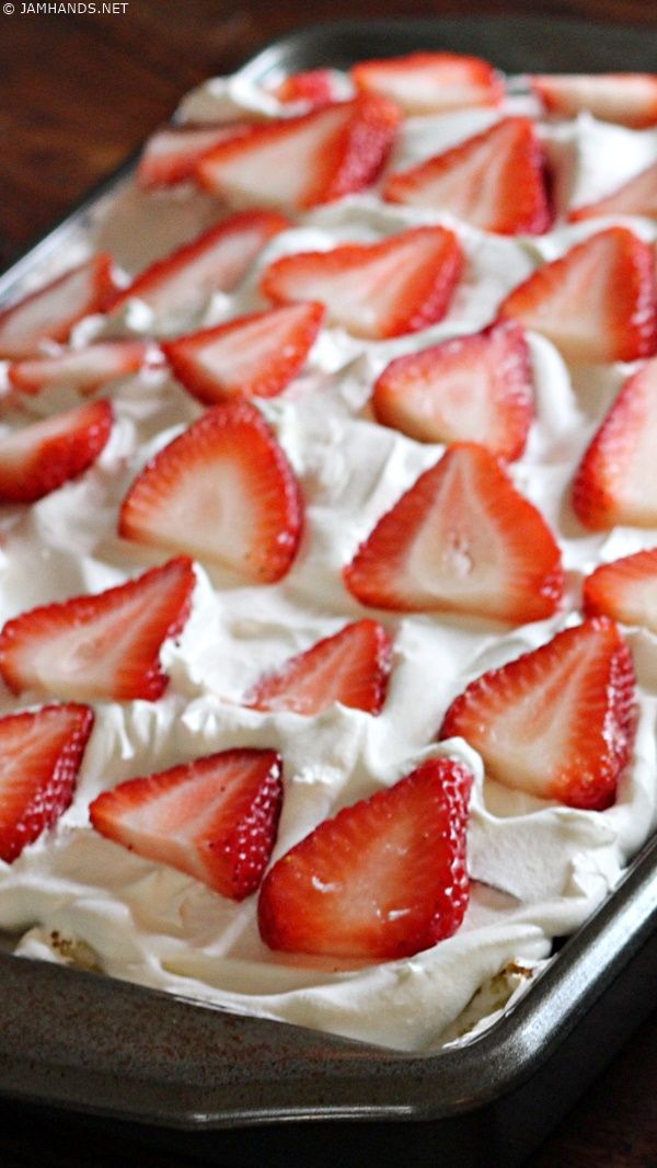 a pan filled with whipped cream and sliced strawberries