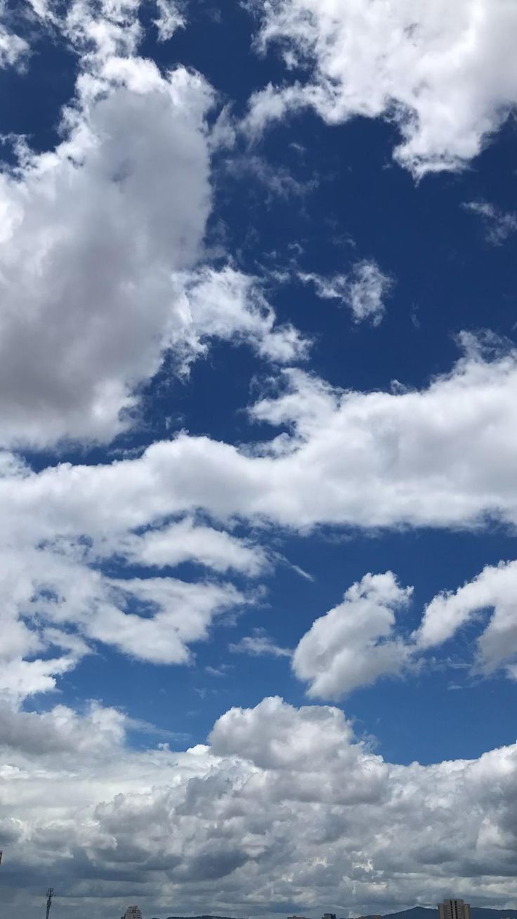 the sky is full of clouds and some buildings