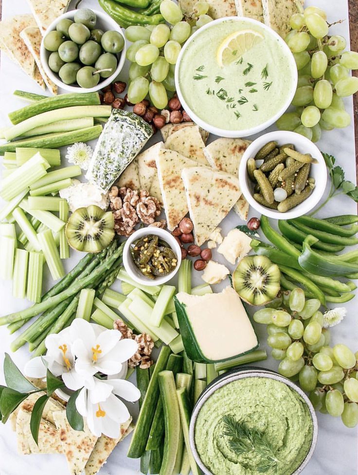 a table topped with lots of different foods and dips on top of each other