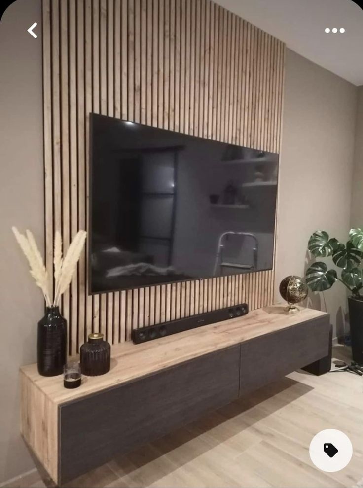 a flat screen tv mounted to the side of a wooden wall in a living room