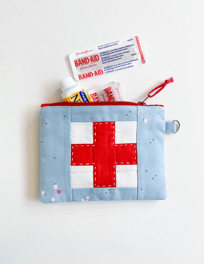 the first aid kit is laid out in a zippered pouch on a white surface