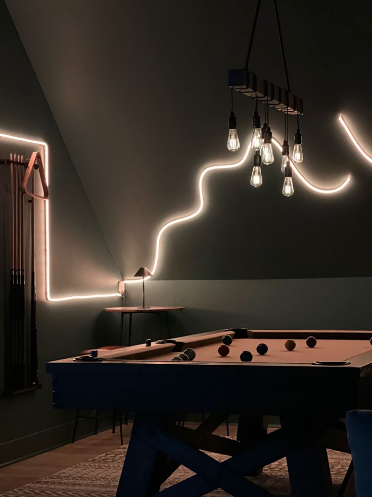 a billiard table with lights hanging from it's sides in a dark room