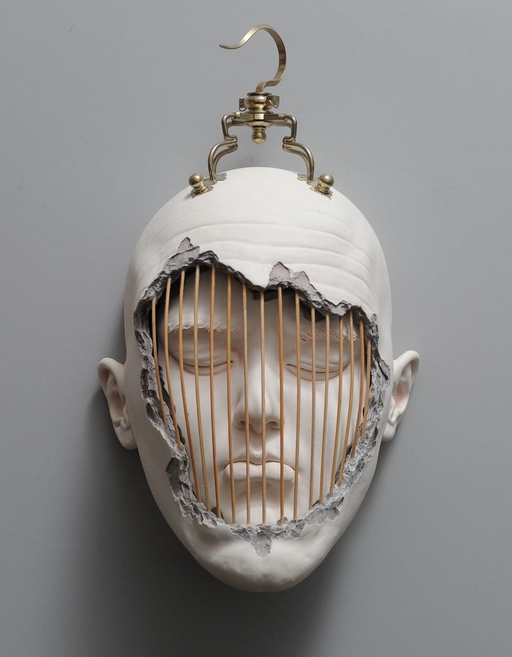 a white mask with a wire cage in it's face hanging from a hook