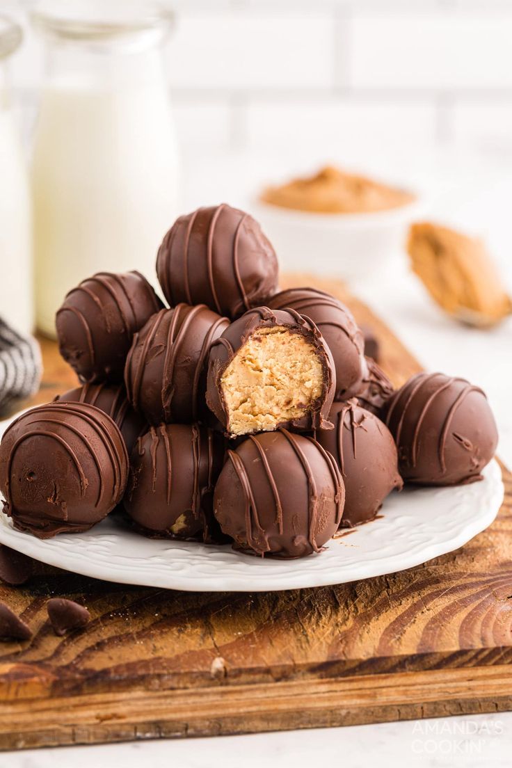 chocolate covered peanut butter balls on a plate next to a glass of milk