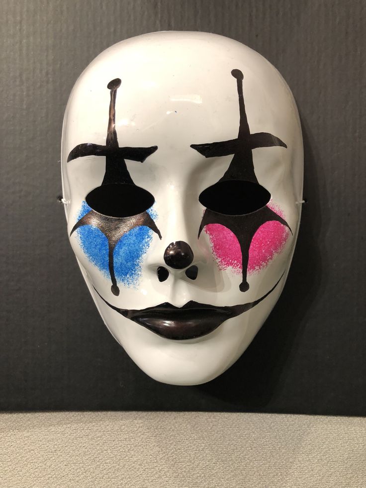 a white mask with blue and pink painted on it