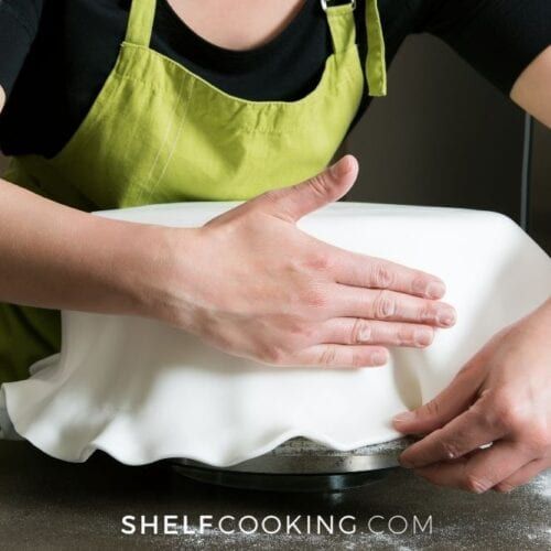 a woman in an apron is making something with her hands