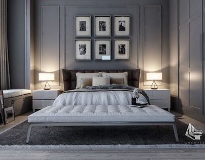 a bedroom with gray walls and pictures on the wall above the bed, along with an ottoman