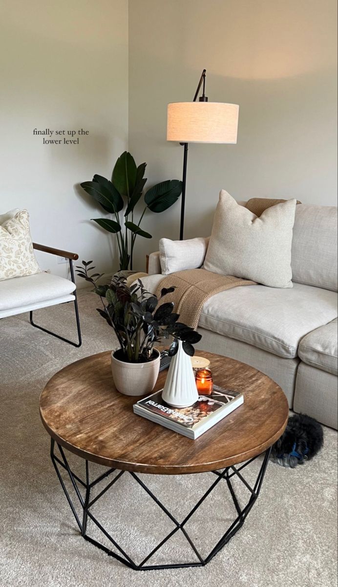 a living room filled with furniture and a lamp on top of a coffee table in front of a couch