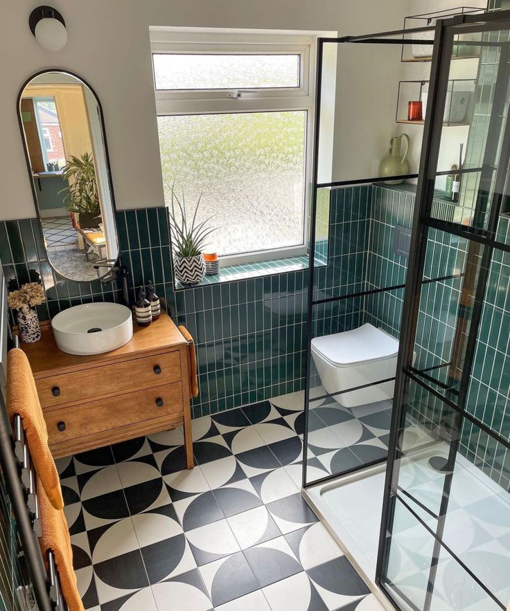 a bathroom with black and white tiles on the floor