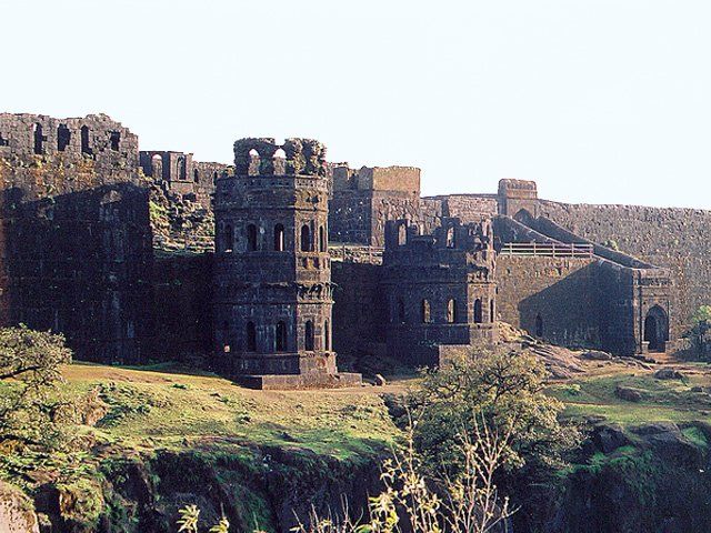 an old castle sitting on top of a lush green hillside