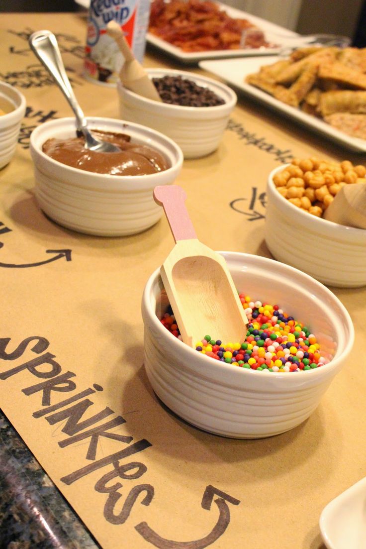 bowls and spoons filled with different kinds of food sitting on a table next to each other