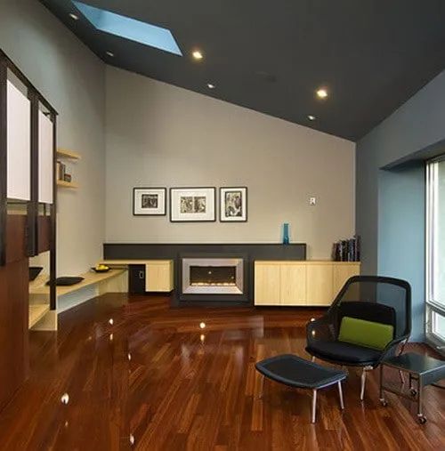 an empty living room with hard wood floors and skylights on the windowsills