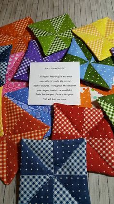 a pile of different colored pieces of cloth with a note on it's side