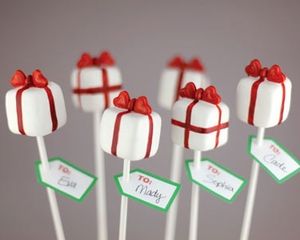 six white lollipops wrapped in red and green paper with presents on them