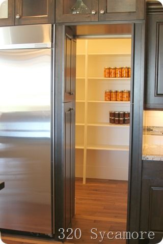 an open refrigerator in the middle of a kitchen with lots of shelves and cupboards