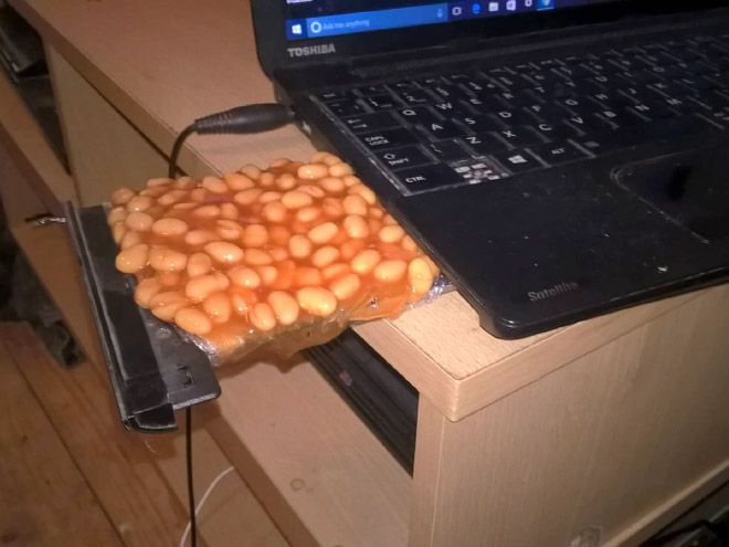 a laptop computer sitting on top of a desk next to a box filled with peanuts