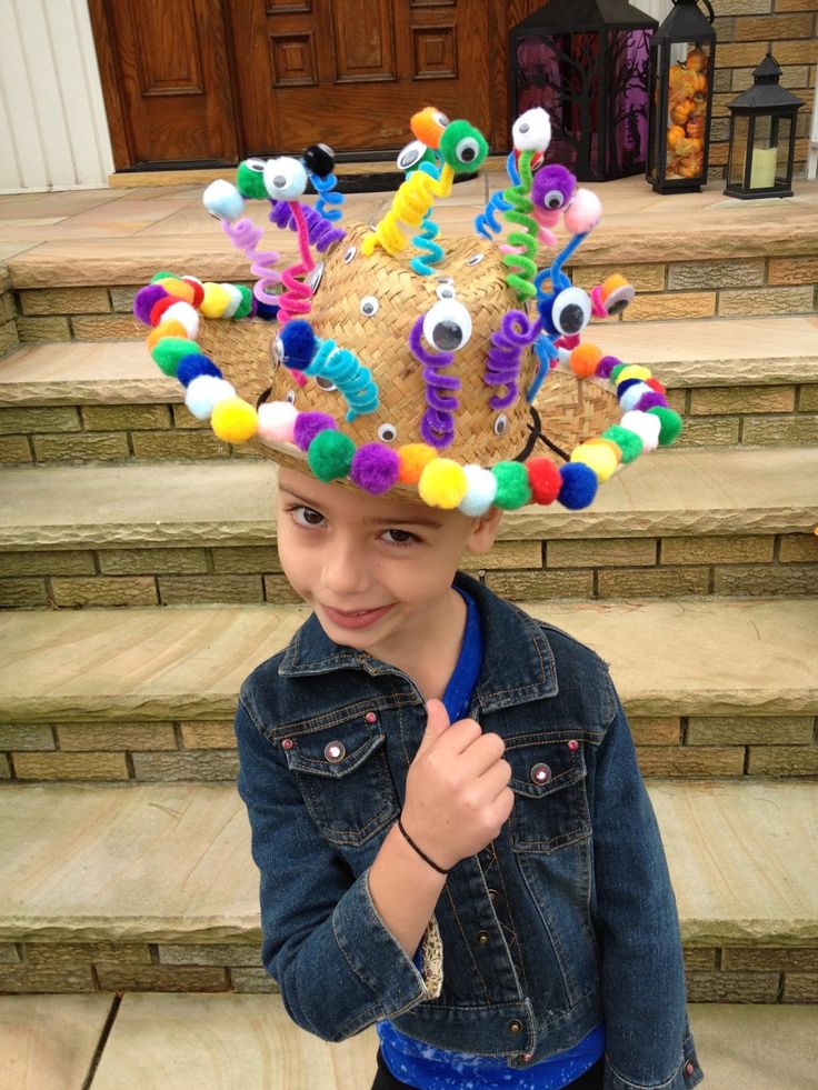 a young boy wearing a colorful hat on top of his head while standing in front of some steps