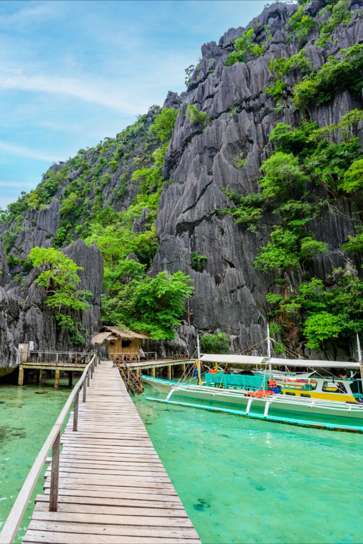 a wooden dock leading to boats in the water