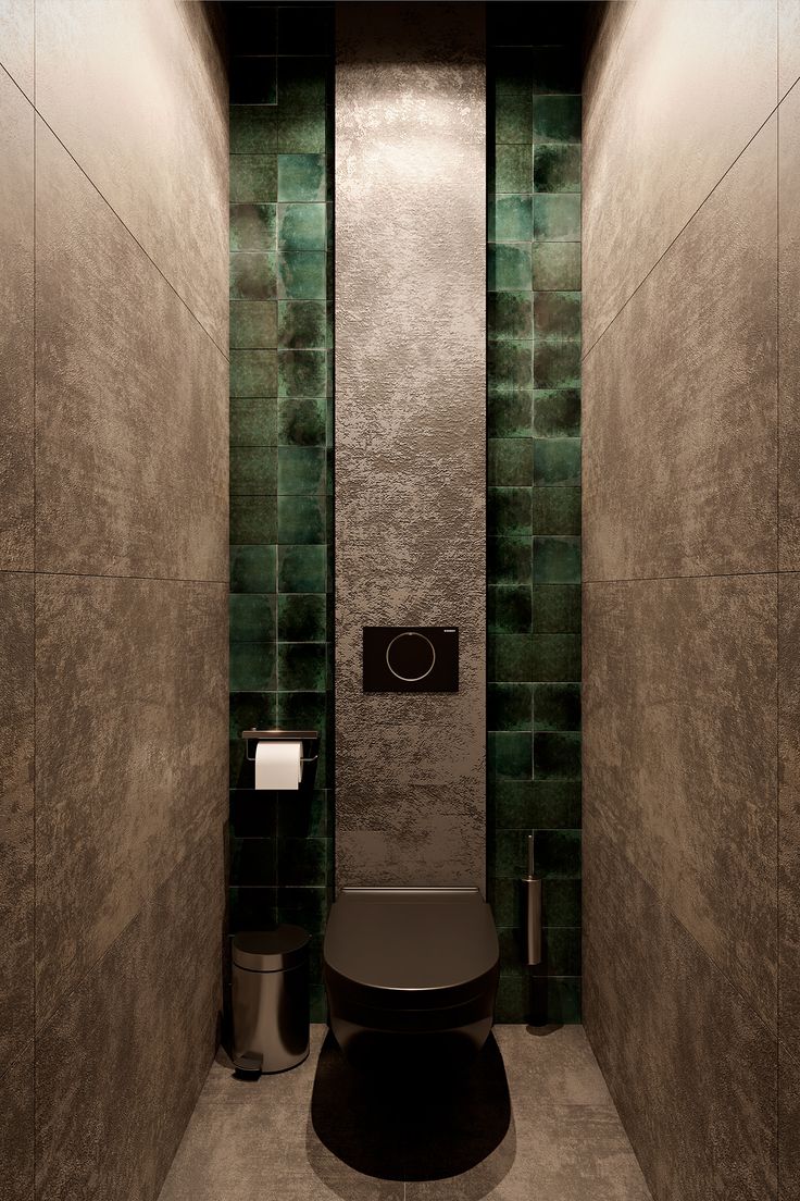 a bathroom with a toilet and green tiled walls