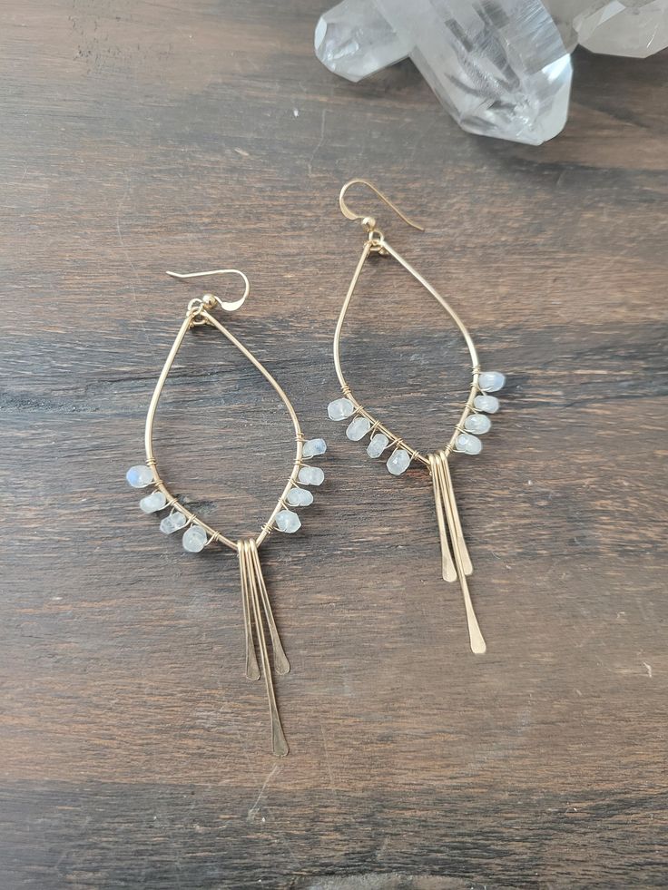 So in love with these Moonstone Tulip Earrings! These beauties are abstract art pieces of tulips that you can wear and take with you on your adventures! They are the perfect addition to your Spring/Summer jewelry and they go with just about anything! They are available in Sterling Silver and 14K Gold Filled. Each piece is hand formed and hammered for texture and shape. Four beautiful Moonstone Gems are wire wrapped up each side of the earring. The length of the earrings are just a tad over 3 in. Artisan Dangle Teardrop Earrings With Ear Wire, Artisan Teardrop Dangle Earrings With Ear Wire, Delicate Wire Wrapped Earrings For Everyday, Wire Wrapped Long Drop Earrings For Everyday, Everyday Wire Wrapped Long Drop Earrings, Everyday Long Drop Wire Wrapped Earrings, Bohemian Teardrop Crystal Earrings For Pierced Ears, Bohemian Teardrop Crystal Earrings, Bohemian Nickel-free Drop Jewelry