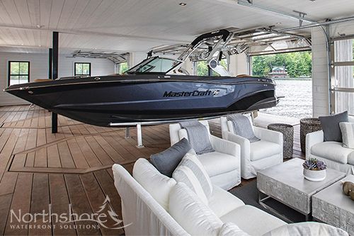 a boat is parked in the middle of a room with white couches and chairs