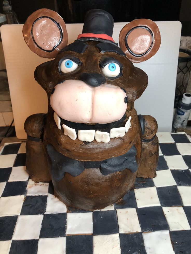 a close up of a statue of a bear on a checkered tile floor with blue eyes