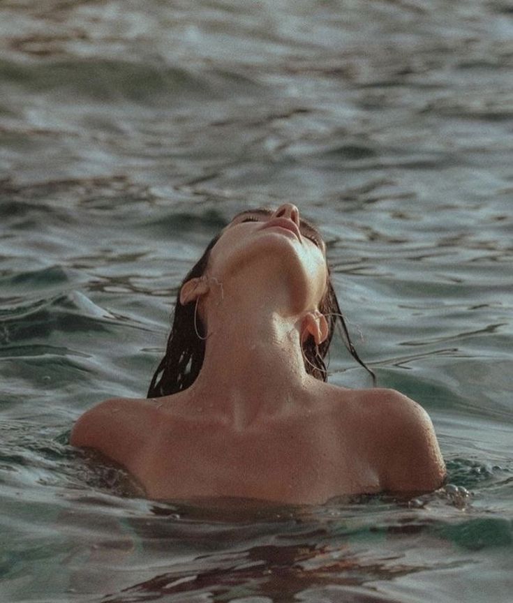 a woman swimming in the ocean with her eyes closed