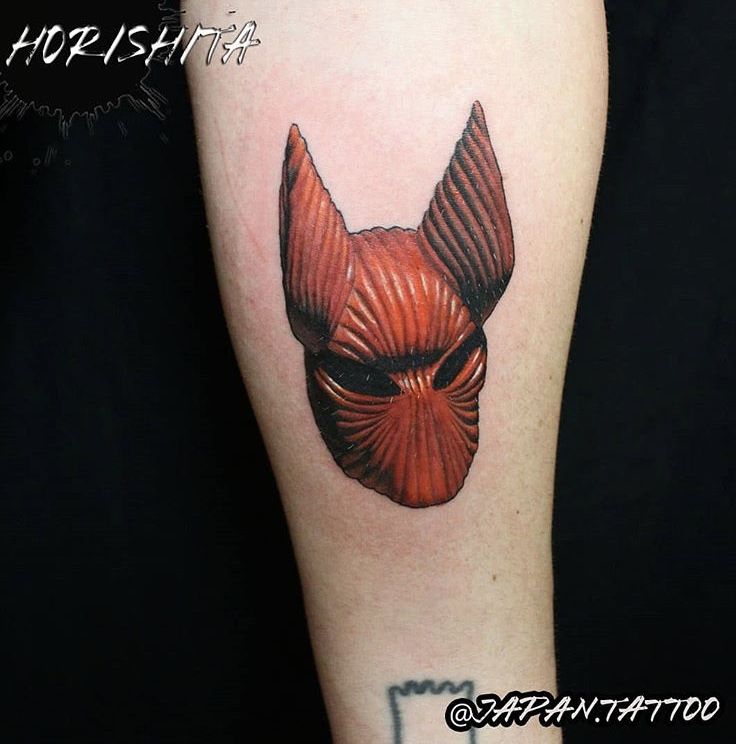 a red devil mask tattoo on the arm