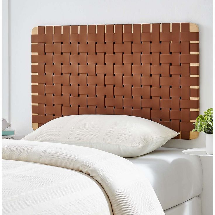 a close up of a bed with a pillow and headboard made out of wood