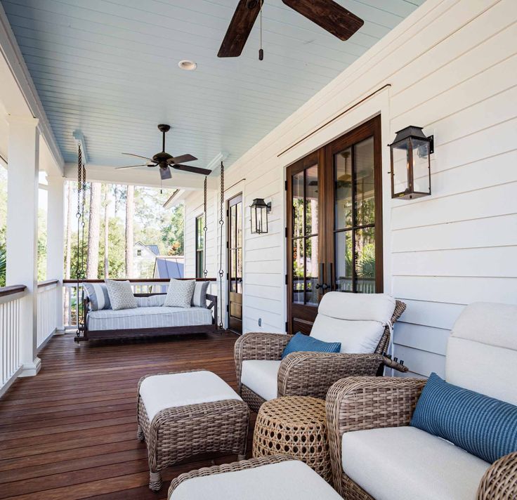 a porch with wicker furniture and ceiling fan