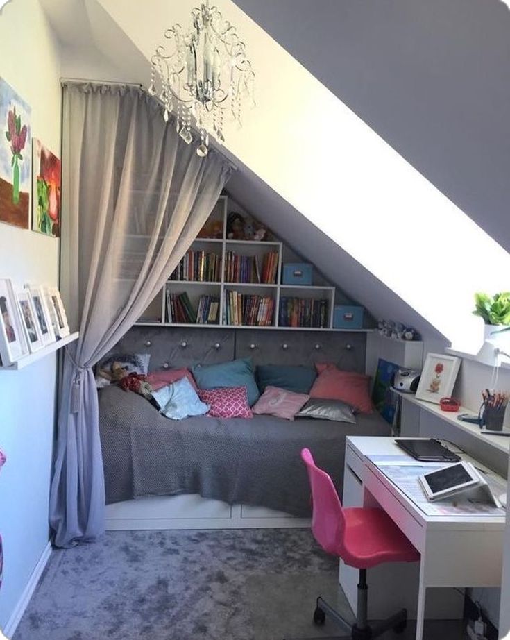 a bedroom with a bed, desk and bookshelf in the corner under a slanted ceiling