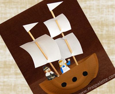 a paper cut out of a pirate ship with white sails and two people on it