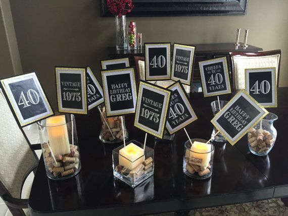 a table topped with lots of candles next to framed pictures and signs on top of each other