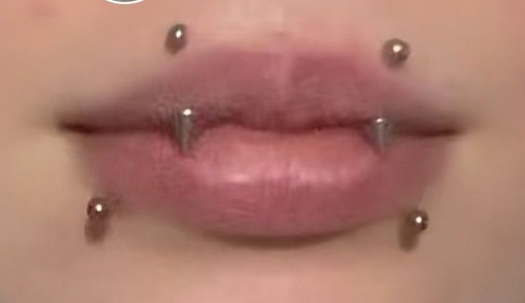 a woman's lips with piercings on them