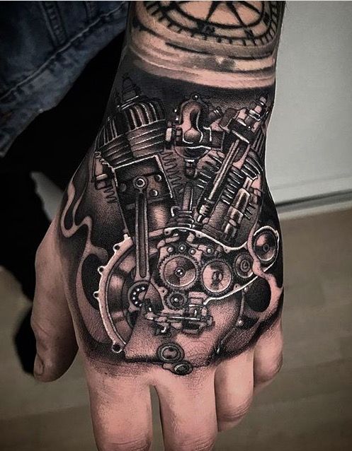 a man's hand with a tattoo on it that has a motorcycle engine in the middle