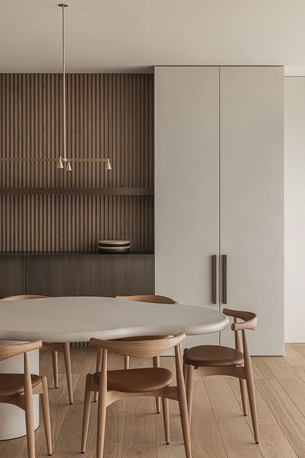 a dining table with four chairs around it in front of a wooden paneled wall