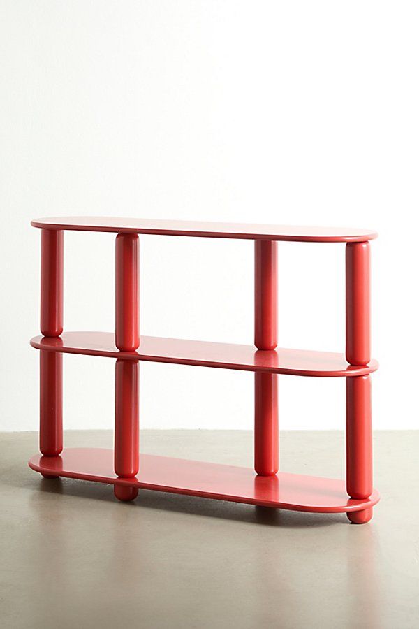 a red shelf sitting on top of a cement floor