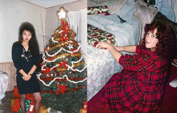 two women in plaid dresses standing next to a christmas tree