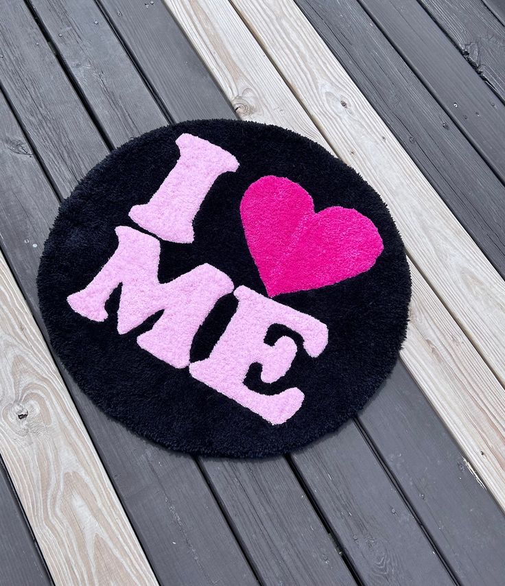 a rug with the word i love me written on it and a pink heart in the center