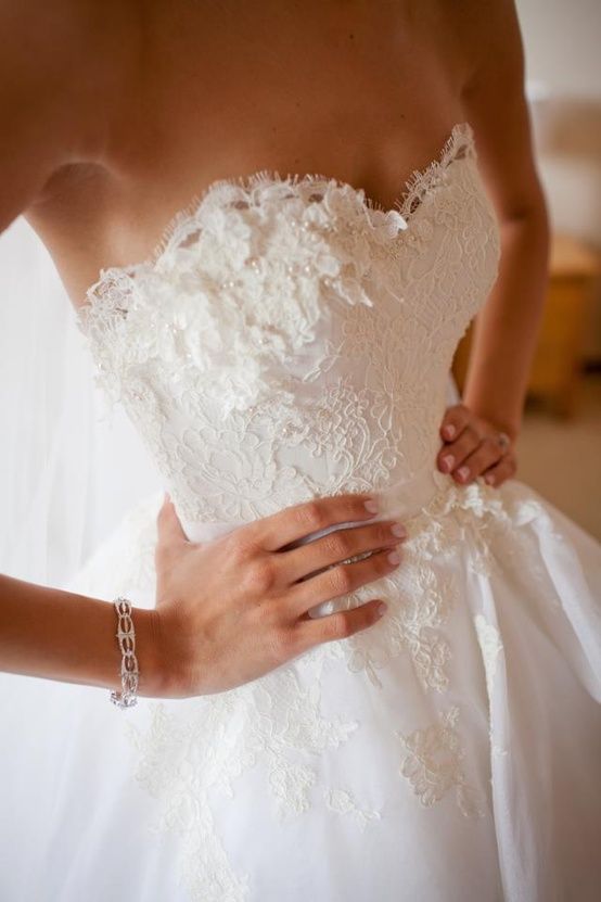 a woman in a wedding dress is holding her hand on the waist