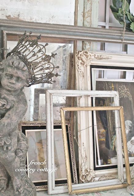 an assortment of antique frames and pictures on a table