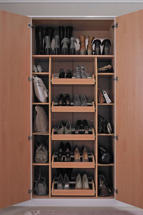 a closet filled with lots of pairs of shoes next to a wall mounted shoe rack