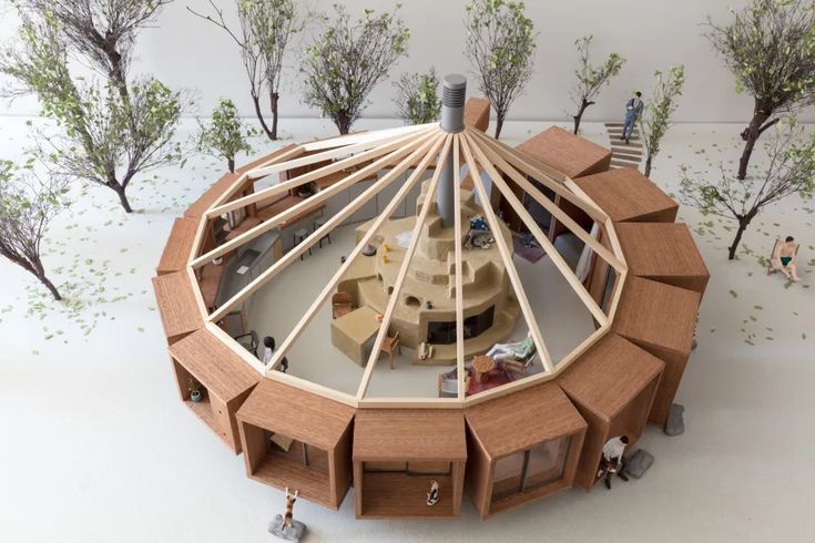 a model of a wooden structure with people standing around it