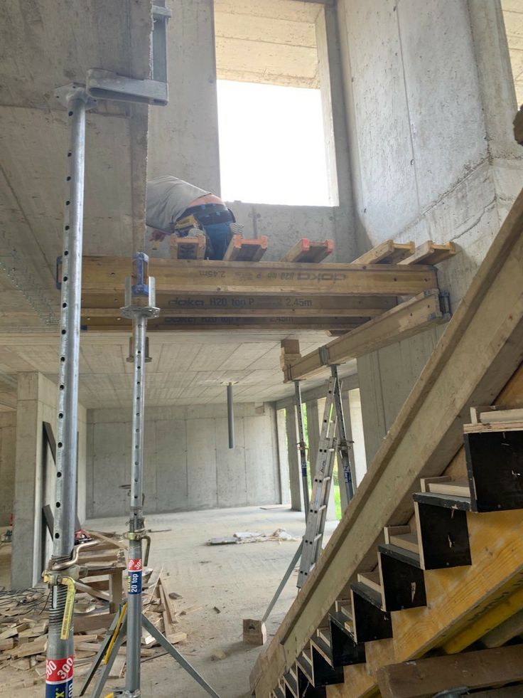 an unfinished room with stairs and construction equipment