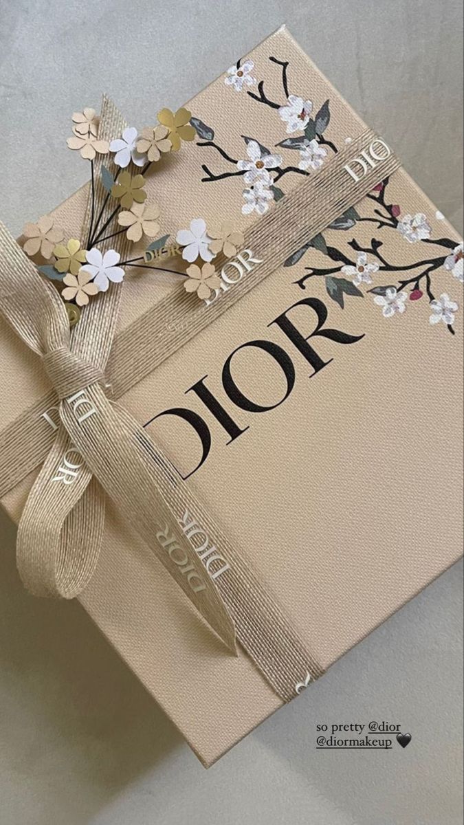 an open gift box decorated with flowers and ribbon