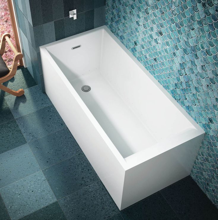 a white bath tub sitting on top of a tiled floor