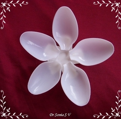 a white flower shaped object sitting on top of a red cloth