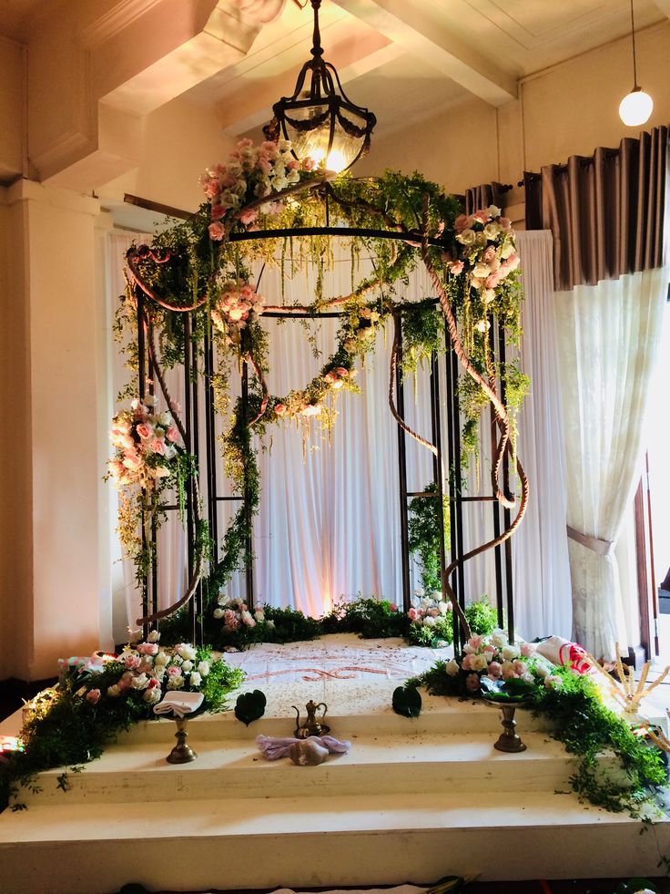 a wedding ceremony setup with flowers and greenery on the stage, decorated with candles